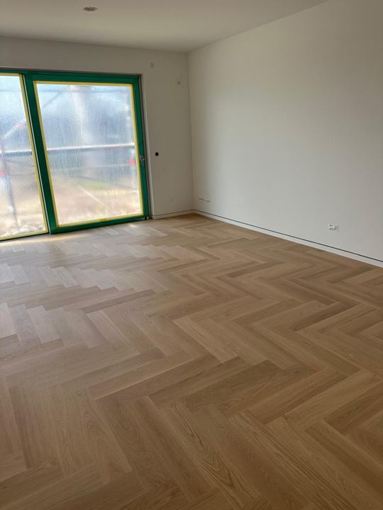Fischgrätparkett in Eiche vor bodentiefem Fenster